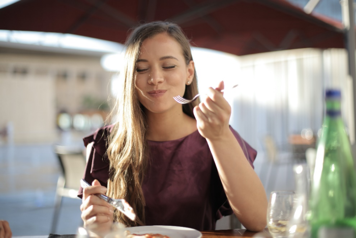 Woman smiling while consuming food